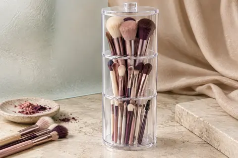 Organisateur transparent à couvercle et trois compartiments, rempli de pinceaux de maquillage