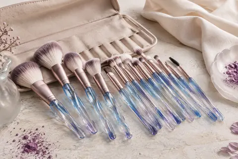 Kit de pinceaux de maquillage en nylon aux manches bleues effet cristal, présenté avec son étui ouvert.